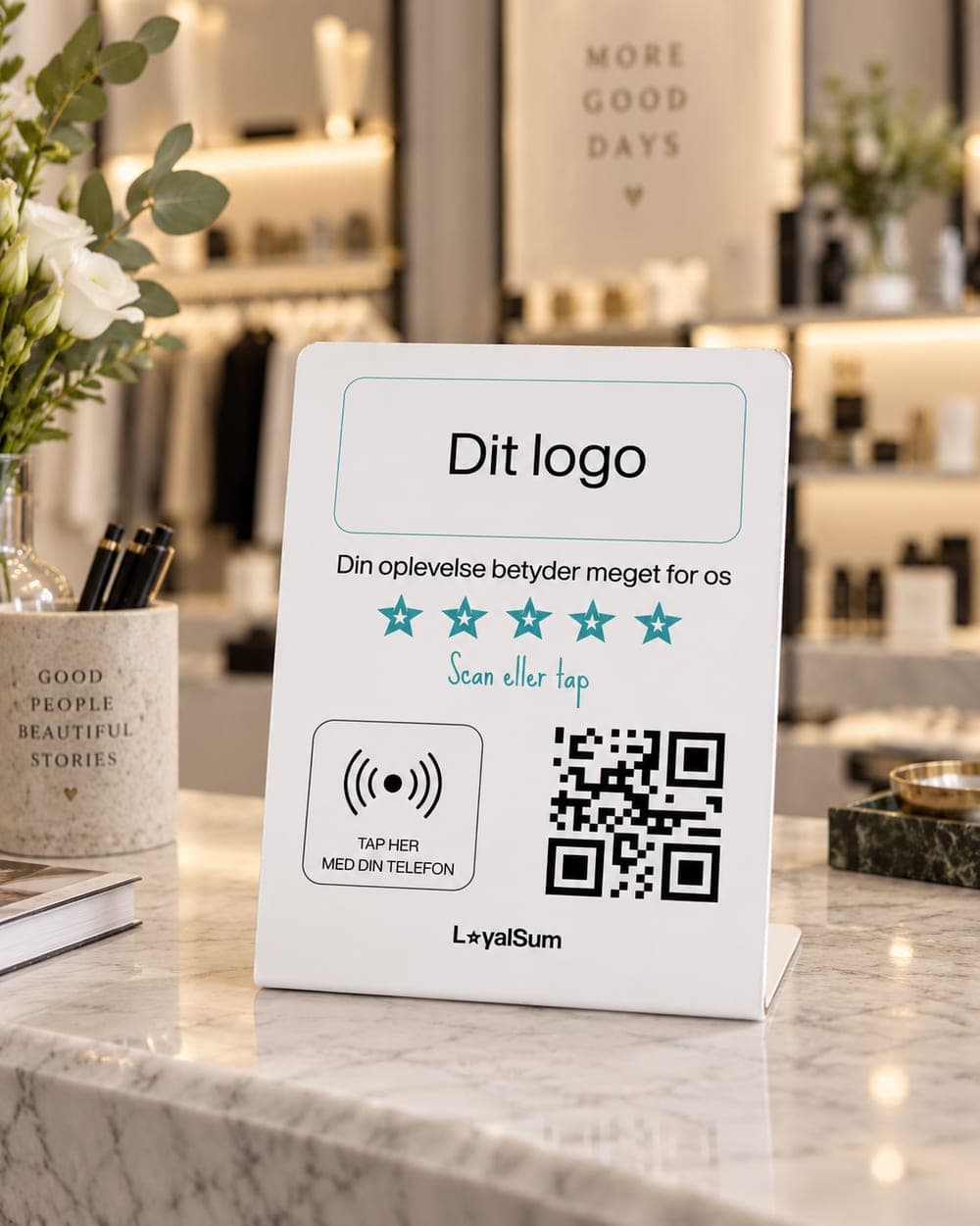 LoyalSum reviewstander på disken i en butik, med QR-kode og NFC-felt